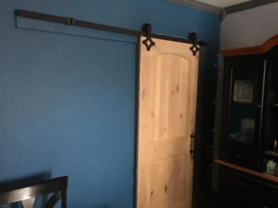 Wooden sliding barn door on blue wall